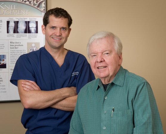 Dr. J. Scott Pigg & Dr. Charles C. Craig posing in front of knee replacement photo