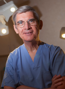 Dr. Stephen Cranston (now retired) poses in blue scrubs - headshot