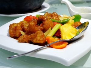 sweet and sour pork with metal spoon on bowl