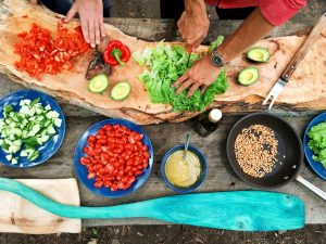 People cutting and holding sliced vegetables