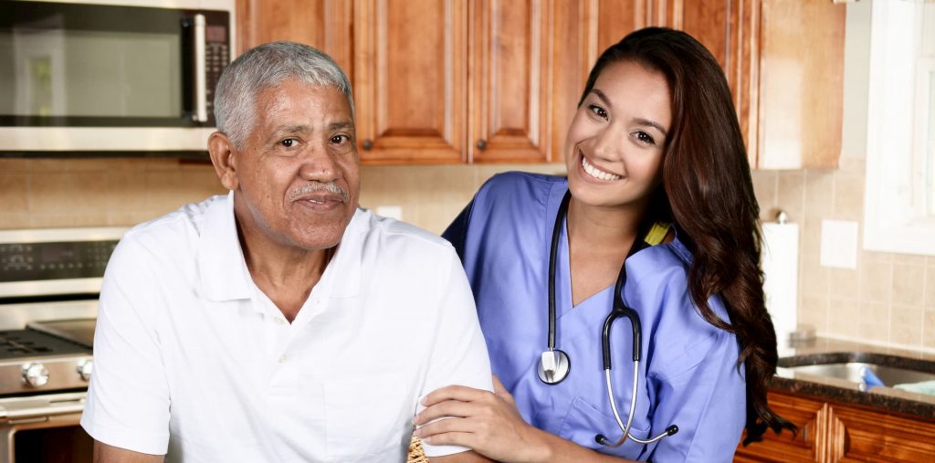 hispanic man in white shirt being helped by a Hispanic nurse for home health care and private duty