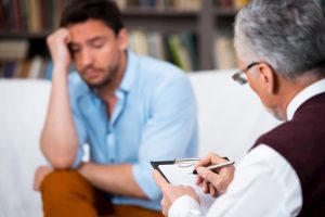 Man sitting with therapist talking about feelings