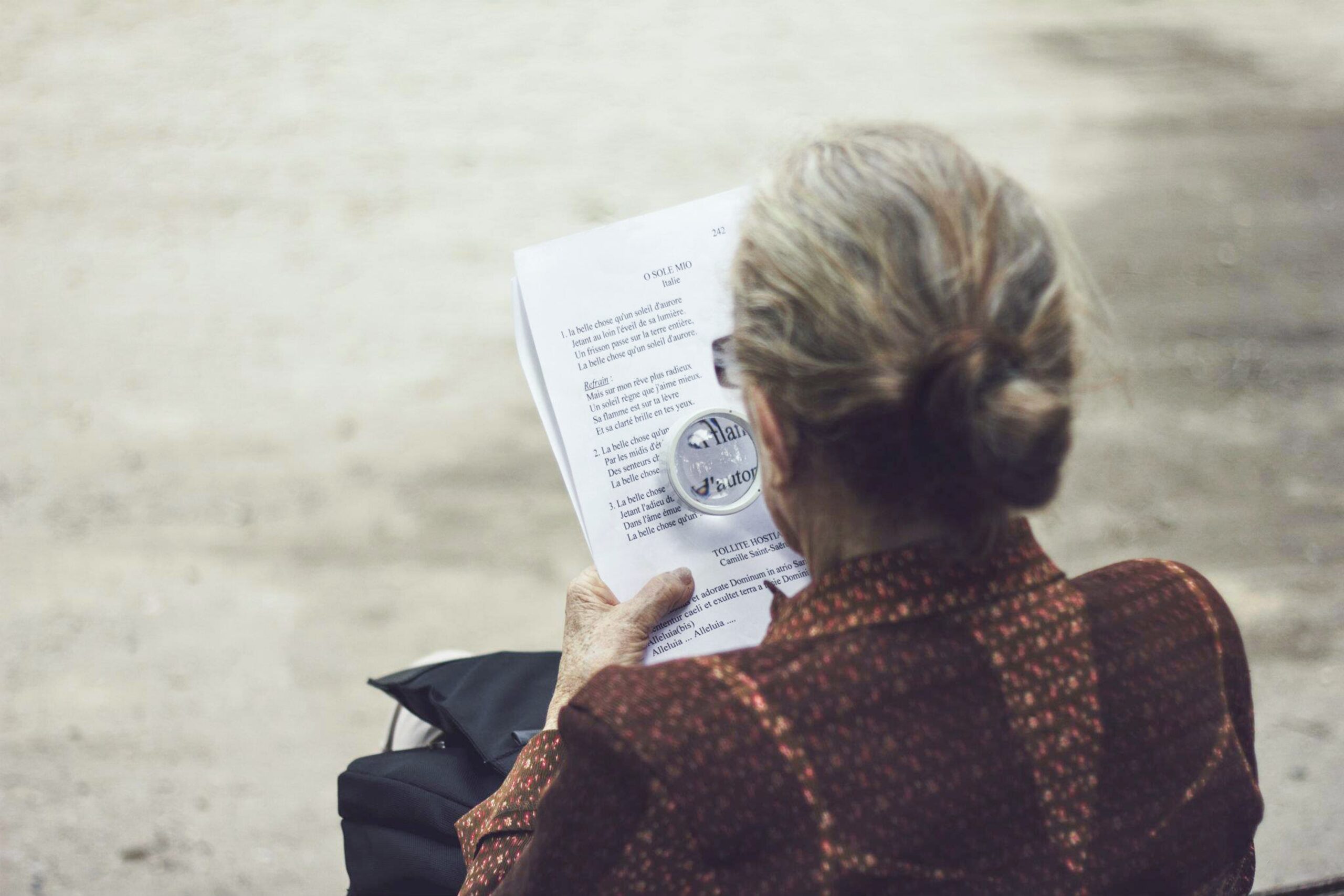 Woman using magnifying glass to read