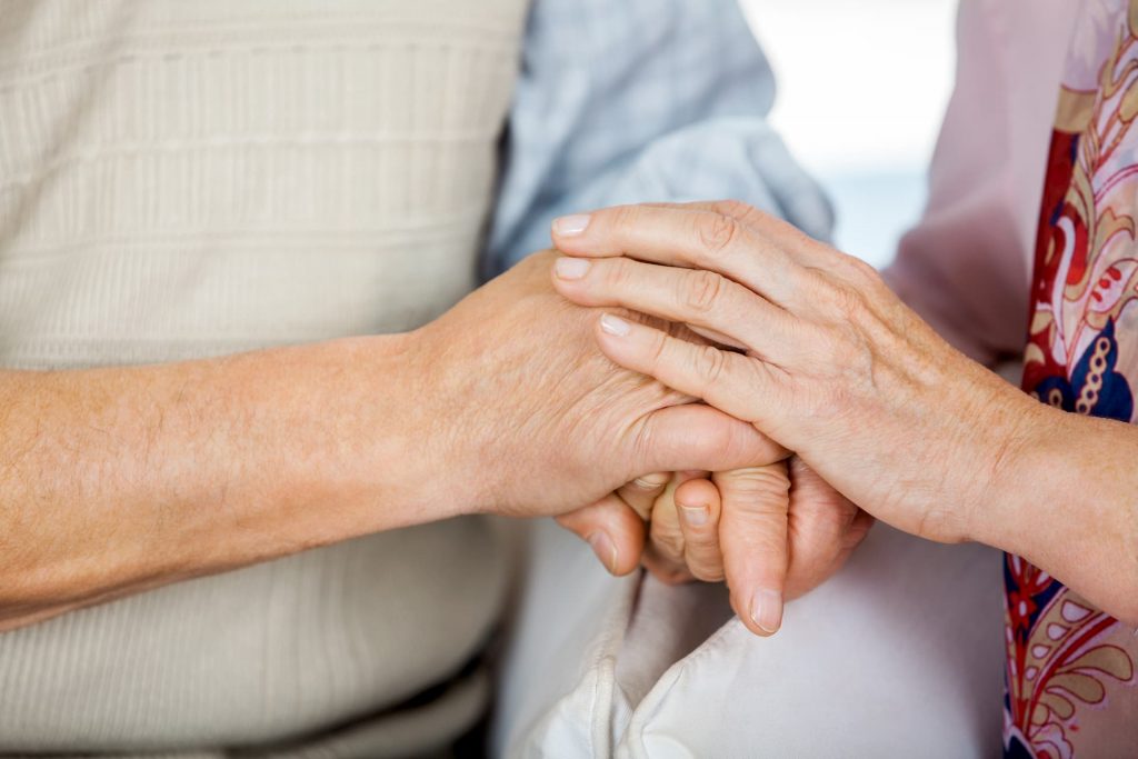 Elderly couple holding hands