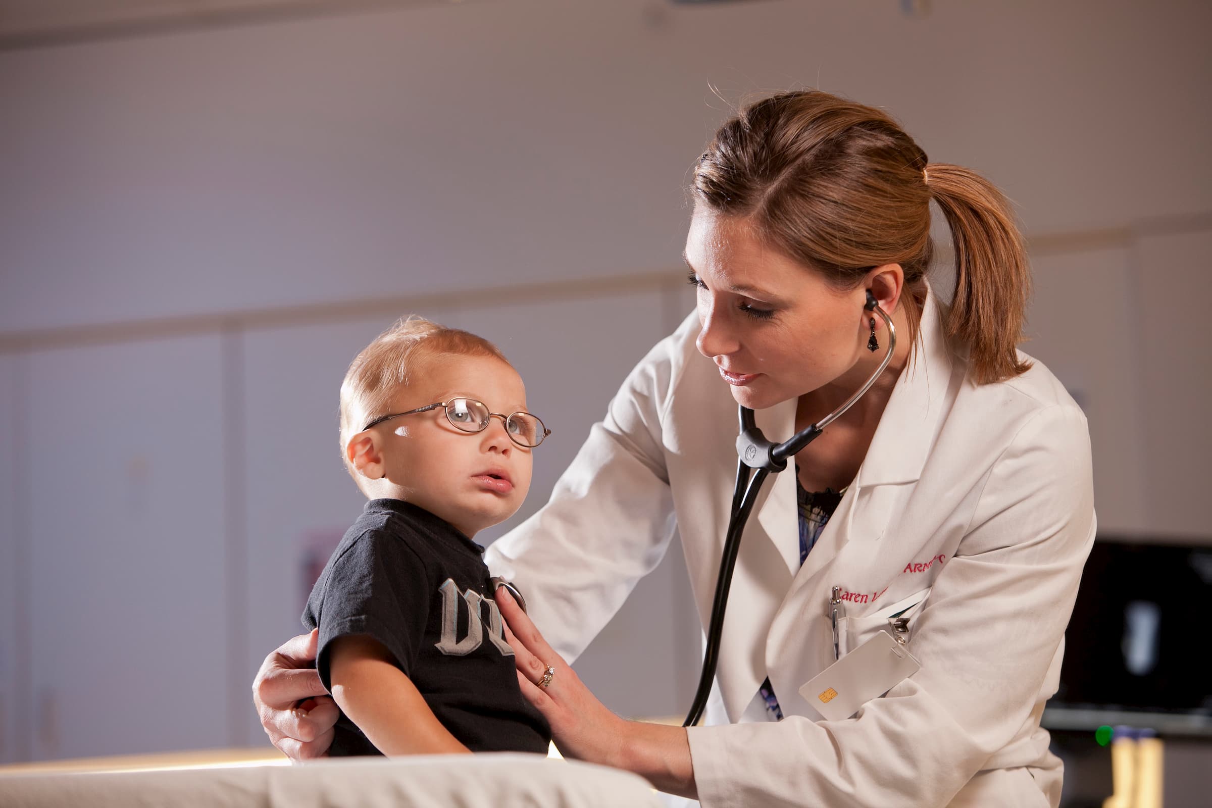 white child getting chest listened to by white woman doctor in emergency room at newton medical center nmc health newton ks