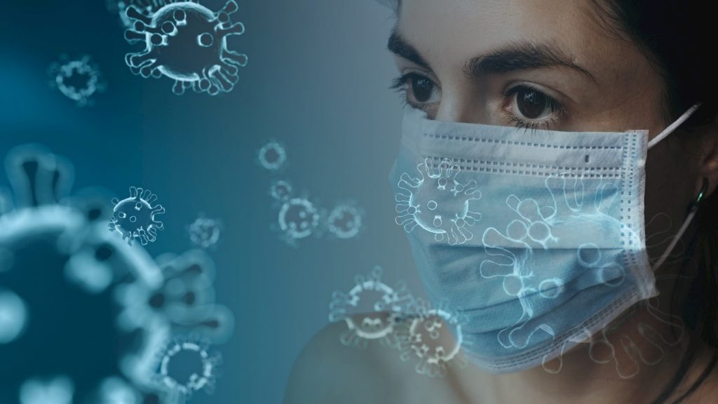 COVID-19 coronavirus background with a woman in a mask staring at virus