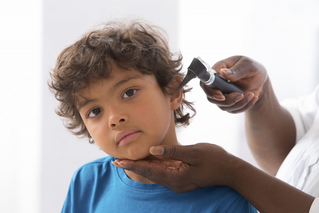 a boy has his ear checked by a doctor at park city family medicine and ENT doctor