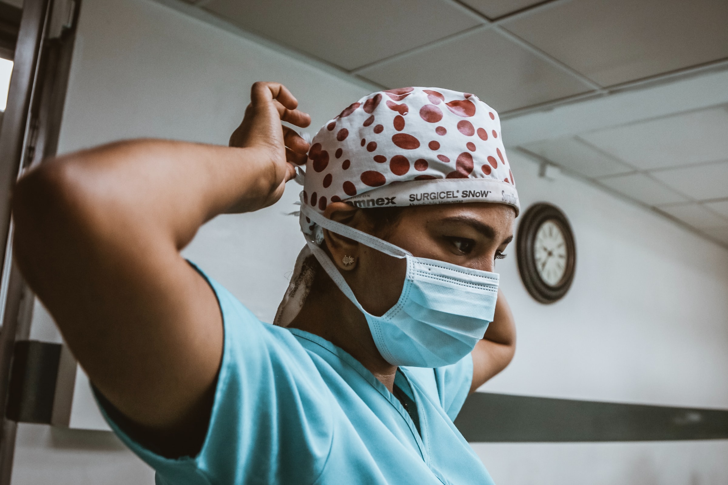 hispanic nurse putting on mask