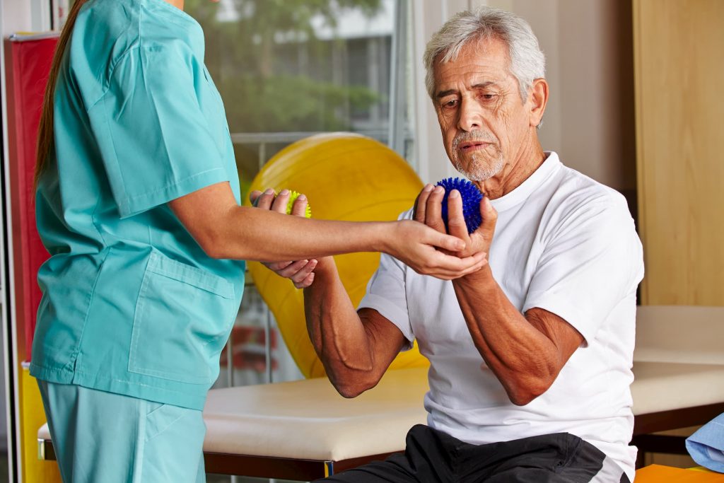 hispanic man doing occupational therapy with balls in hand