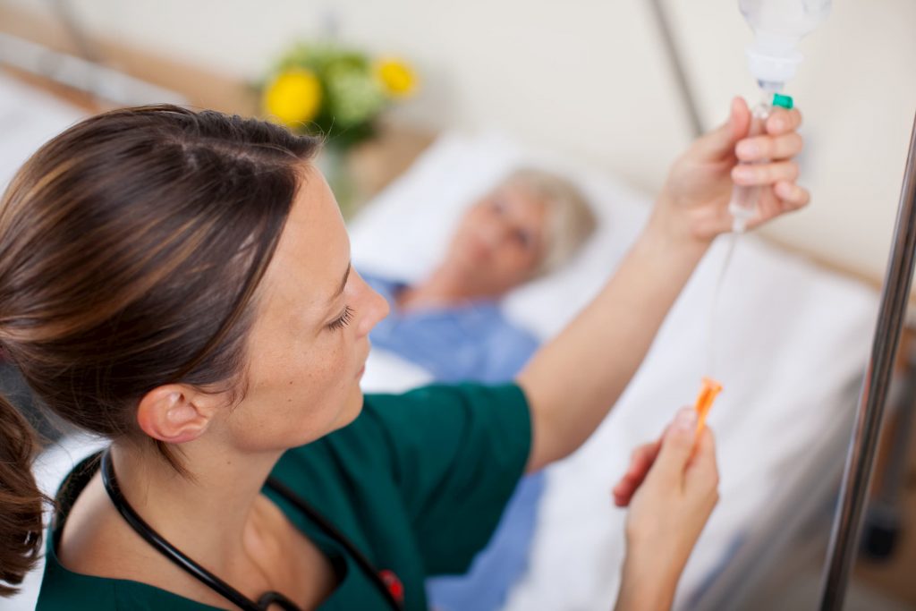 nurse putting giving patient infusion therapy in hospital