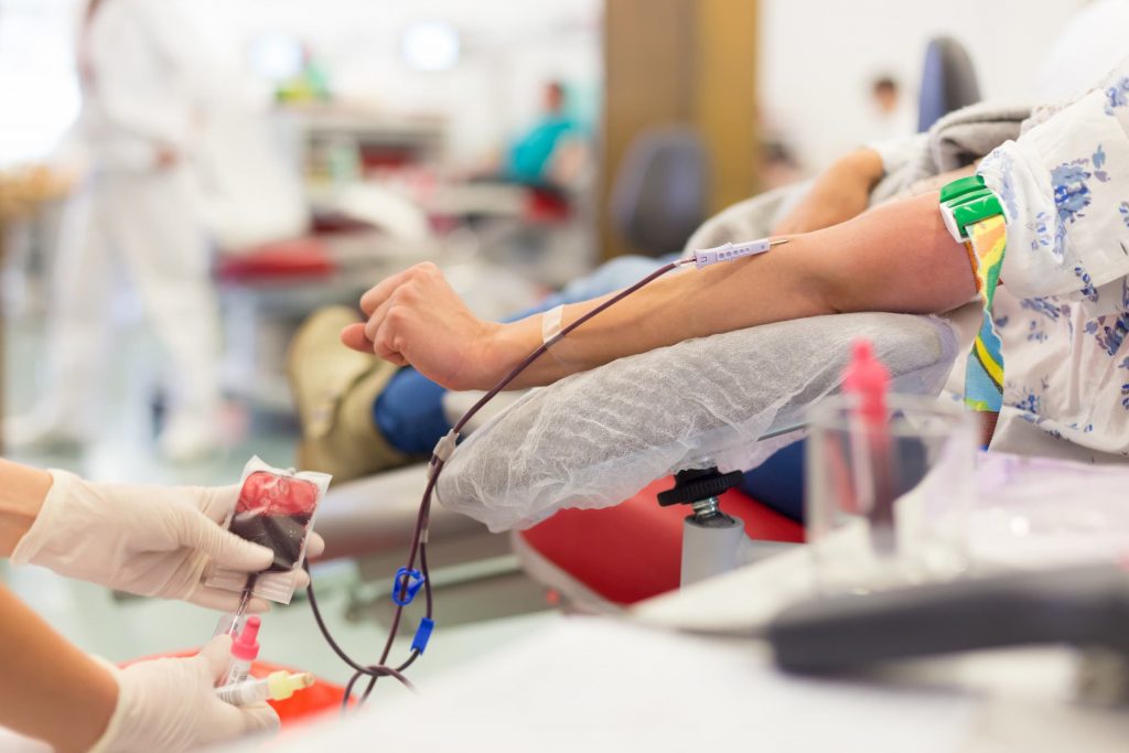 patient laying in infusion therapy getting blood transfusion through iv in her arm