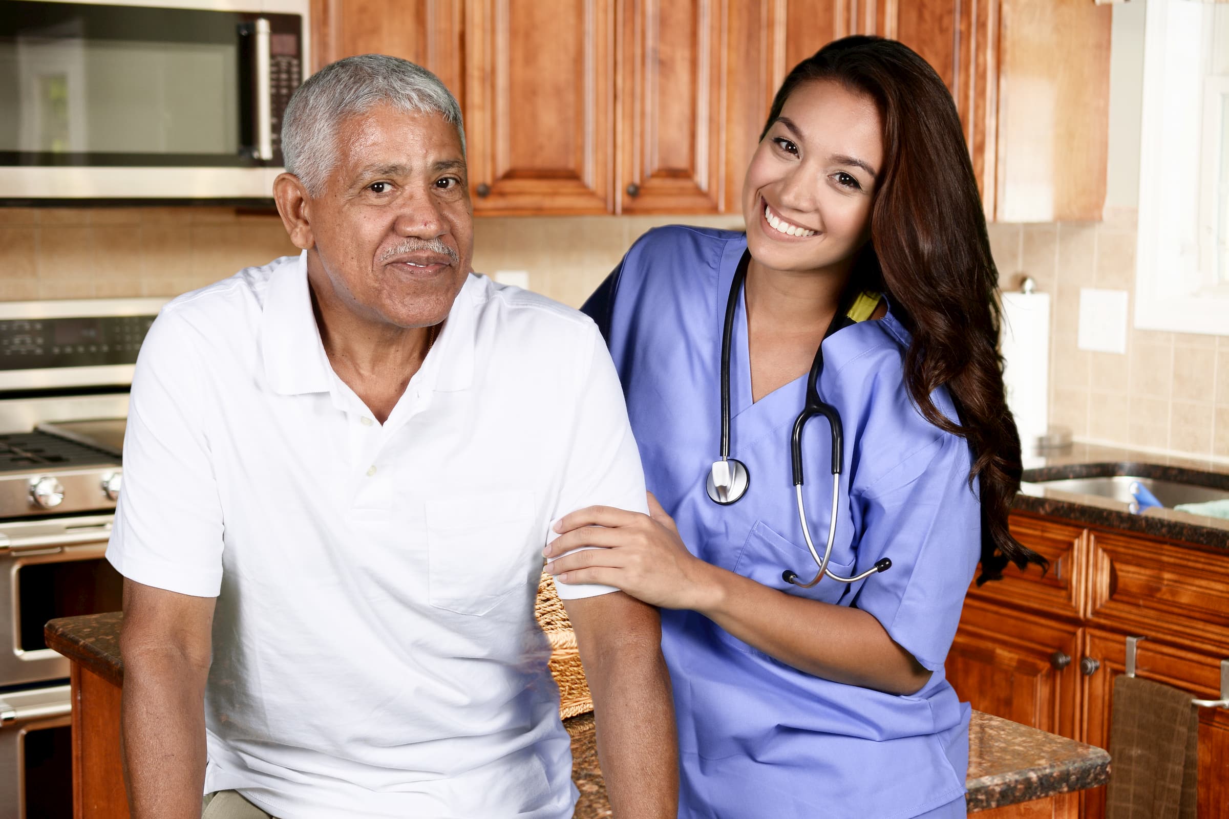 hispanic man in white shirt being helped by a hispanic nurse for home health care and private duty