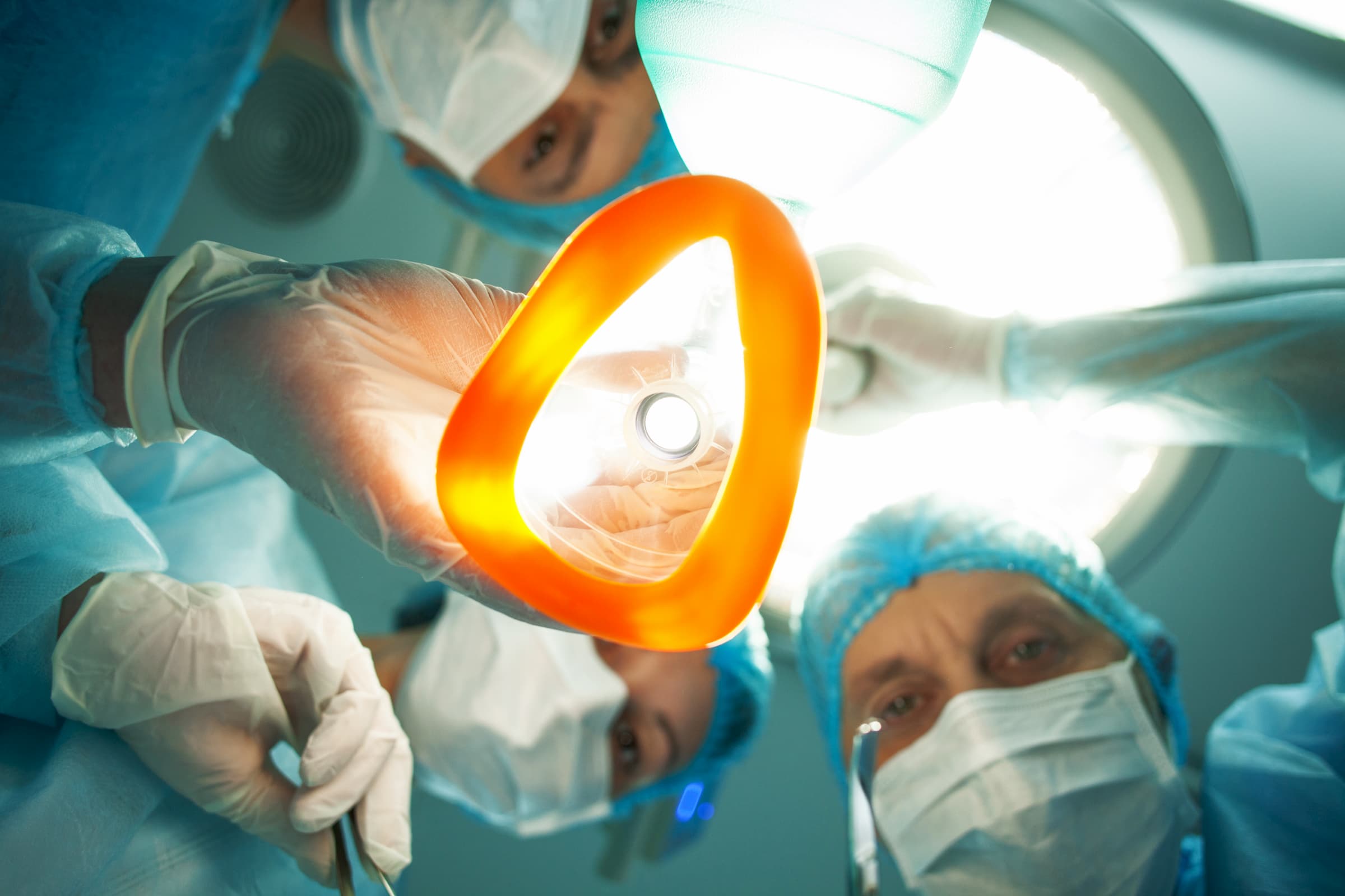 surgeons looking down over patient POV with oxygen mask