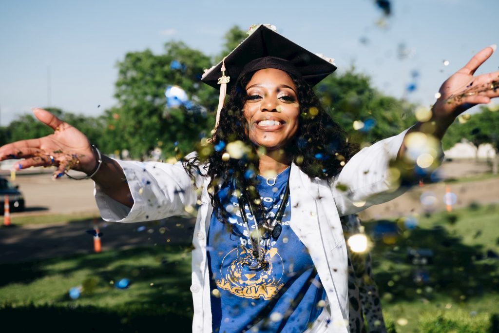 black nurse throwing confetti in graduation showing awards and recognition for healthcare professionals stock image