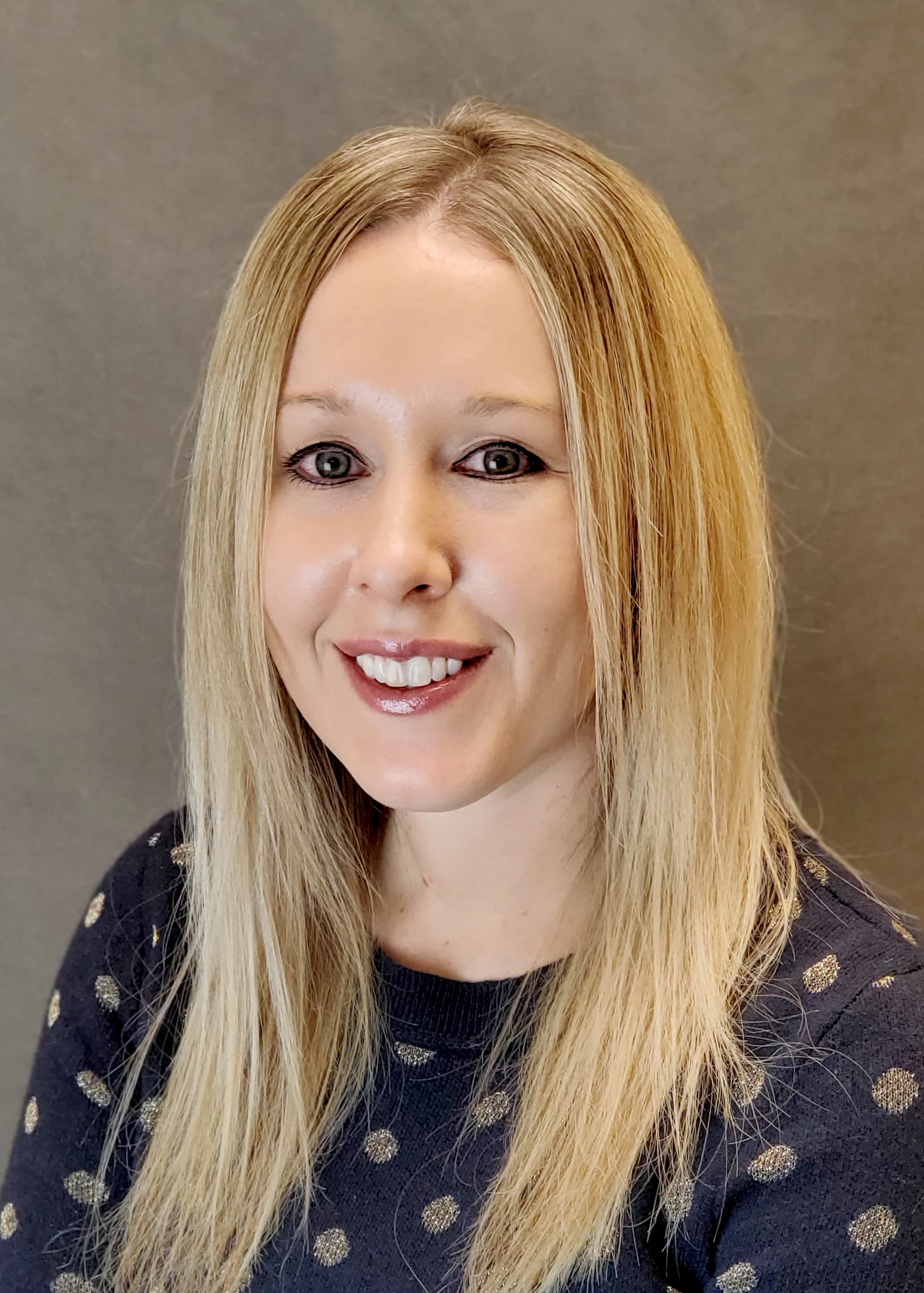 headshot of liz wilson elizabeth wilson in dark blue shirt with polka dots smiling