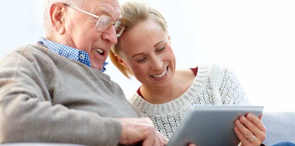 white senior man with white young female woman looking at ipad/tablet for alzheimer's & diabetes support group event
