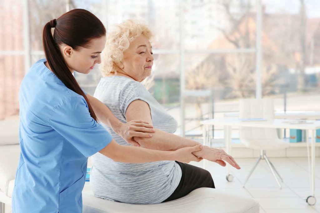 white senior woman and physical therapist occupational therapist working on her elbow joint pain