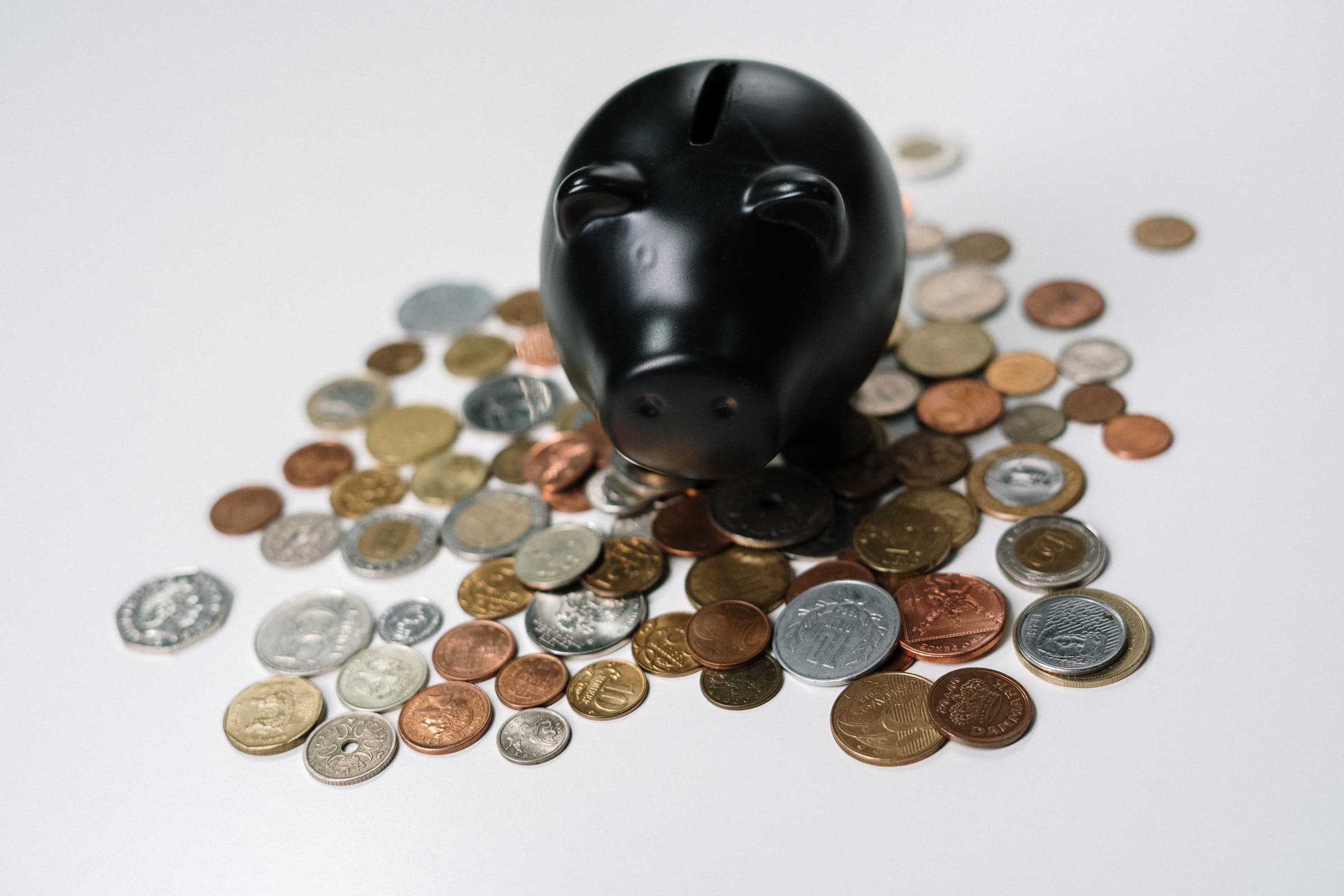 black pig black piggy bank with coins money dollars quarters dimes nickels pennies on a white background stock for billing and collection policy