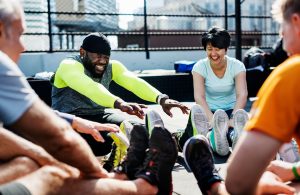 group of people sitting in circle stretching and exercising, how to not get hurt while exercising, warm-up and cool-down stretching muscles