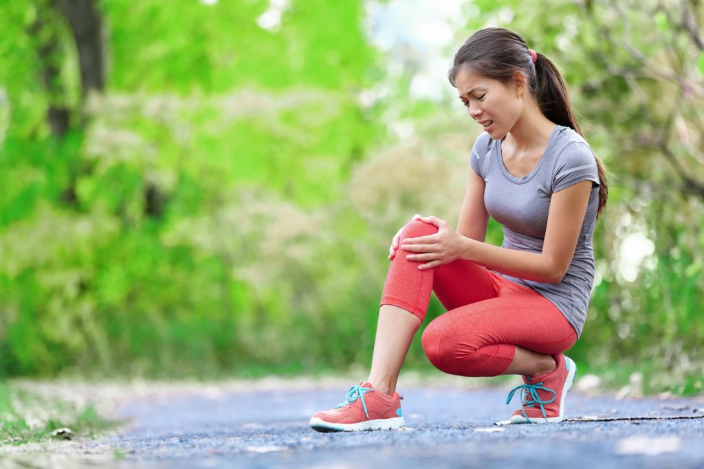 middle-aged asian woman holding knee because she has knee pain while walking every day arthritis treatment