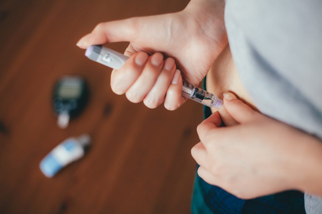 someone with diabetes doing an insulin injection into their stomach for diabetes education