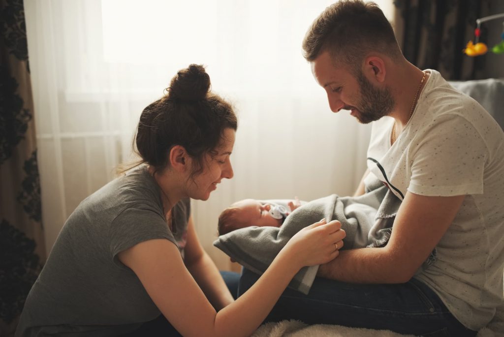 mother and father with newborn in hospital room, new baby, first-time dad