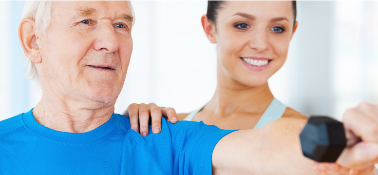 white senior man holding weight working with physical therapists for LSVT LOUD Parkinson's Disease therapy