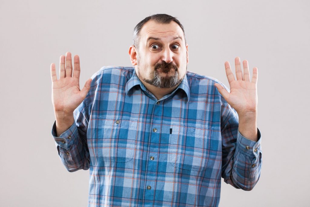 hispanic fan making funny "i don't know" face with hands up in air