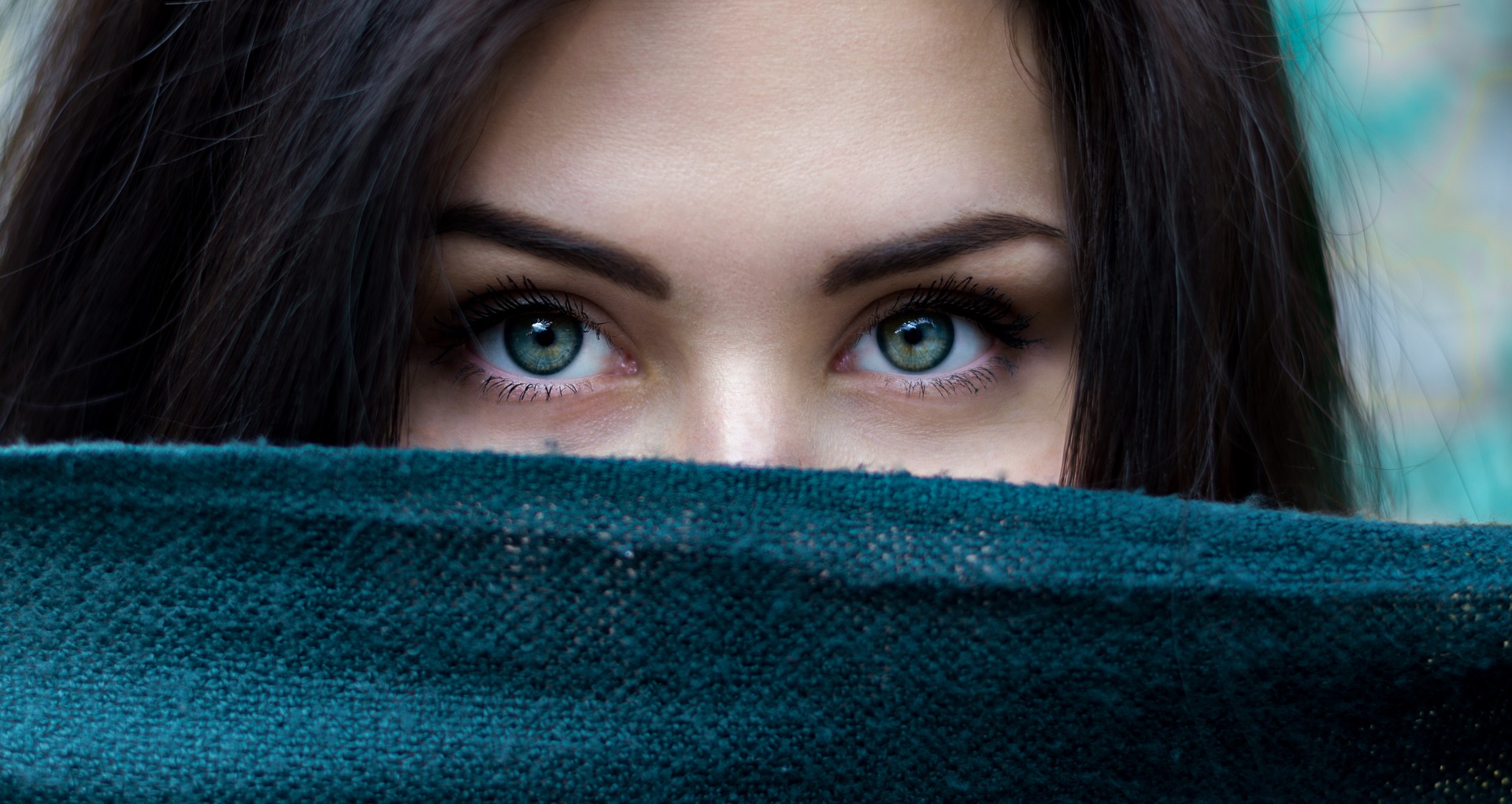 women with blue/green eyes with face obscured by blue towel