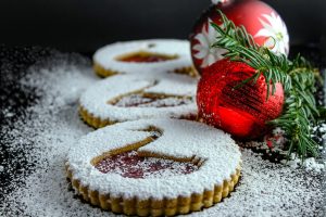 Holiday dessert spread with cookies coated in powdered sugar and holiday decorations nearby
