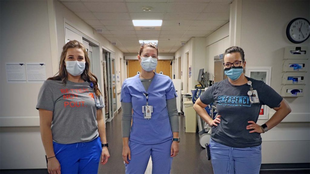 Three hospitals workers pose for a photo in the emergency department