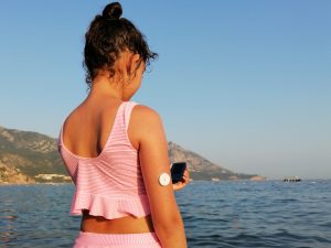 Girl checks glucose level by ocean