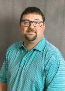 a man in a blue shirt with glasses