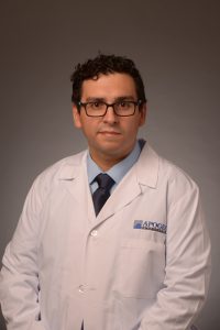 a male doctor in a white coat and glasses