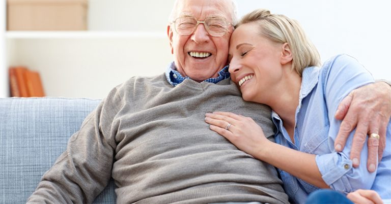 old couple laughing and cuddling on the couch after cardiac care cardia nuclear stress test