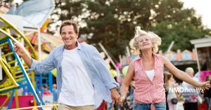 couple holding hands at a carnival while thinking about 10 tips that can keep them feeling young