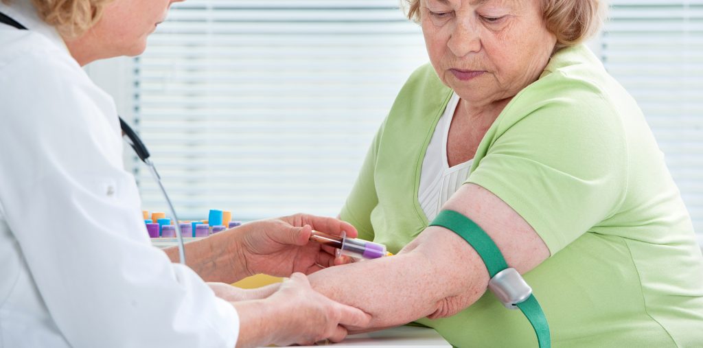 nurse drawing a blood sample from a woman for lab services