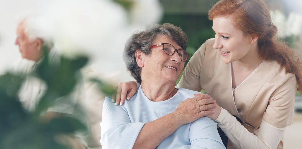 nurse assisting an elderly woman in senior behavioral health unit