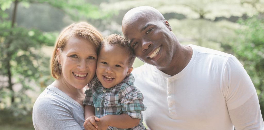 man woman and toddler smiling and looking at camera after visiting an NMC Health Family medicine location
