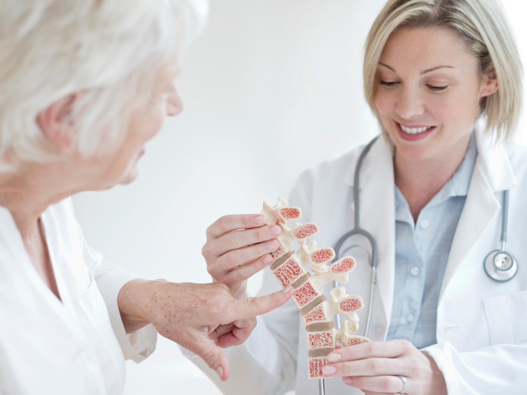 Doctor discussing osteoporosis with old female patient