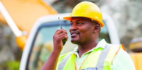 industrial worker talking on walkie-talkie at mining site