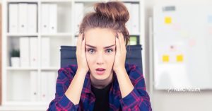 stressed young woman holding her head in her hands