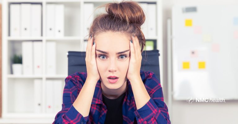 stressed young woman holding her head in her hands