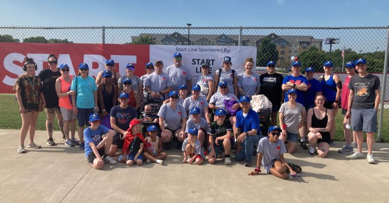 group photo of people outside wearing blue hats