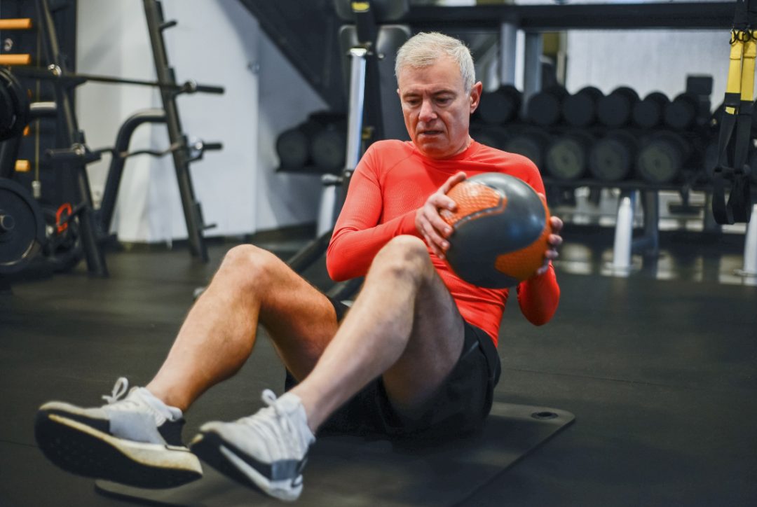 motivated about working out this older man is doing ab exercises