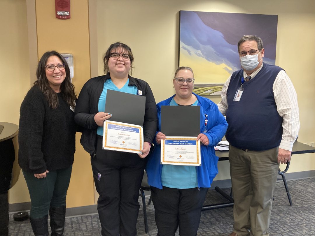 Smiling women receiving awards for excellence