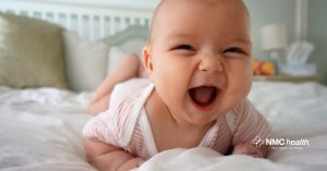 smiling, safe baby during tummy time