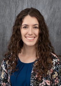 a woman with long brown hair smiling