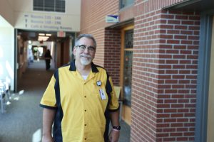 Smiling man standing in the hall outside of a hospital chapel