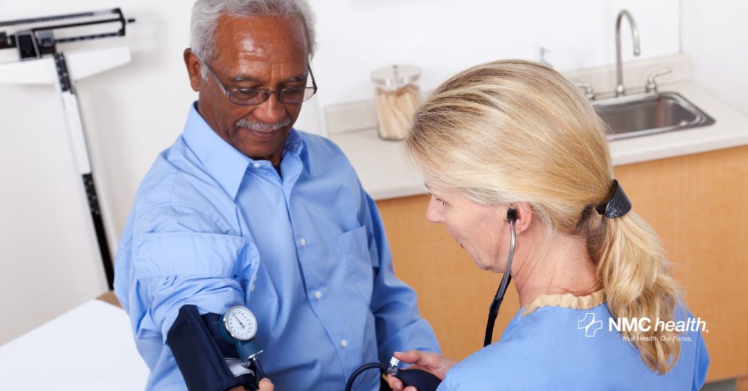 female healthcare provider takes blood pressure of older african-american man